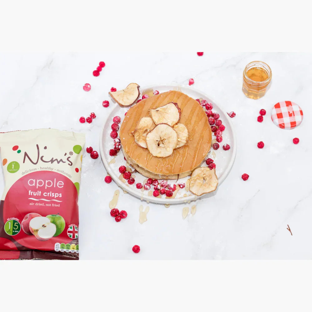 Nim's apple air-dried fruit crisps with pancakes, honey, and berries on white background